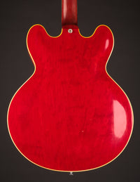 Red electric guitar body on a dark background