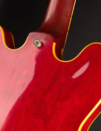 Close-up of a red guitar with a black background