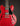 Red electric guitar with a black pickguard on a dark background
