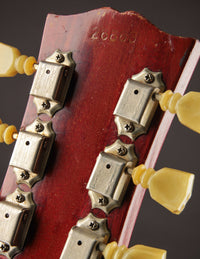 Close-up of a guitar's headstock with tuning pegs and serial number