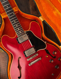 Close-up of a red electric guitar in case with yellow interior