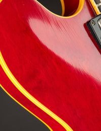 Close-up of a red guitar with yellowed binding