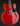 Red electric guitar with a black pickguard on a dark background