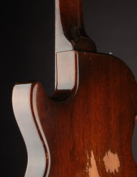 Back view of an electric guitar on a dark background