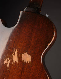 Back view of an electric guitar on a dark background