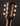 Close-up of a guitar headstock with tuning pegs on a dark background