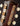Close-up of a guitar headstock with tuning pegs on a dark background