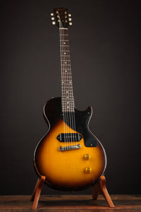 Electric guitar on a stand against a dark background