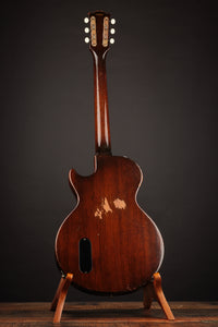 Electric guitar on a stand against a dark background