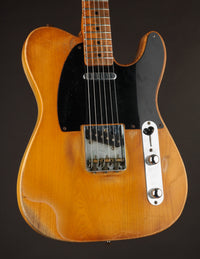 Telecaster guitar with a blonde finish on a dark background