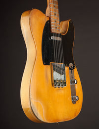 Telecaster guitar with a blonde finish on a dark background