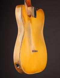 Telecaster guitar with a blonde finish on a dark background, side and back view