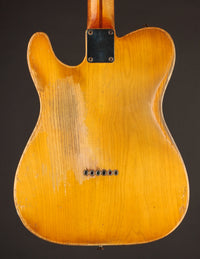 Back view of a worn electric guitar with a dark background