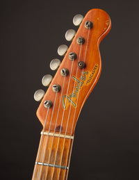 Close-up of a Fender Telecaster guitar headstock on a dark background