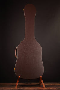 Guitar case on a stand against a dark background