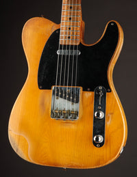 Telecaster guitar with a blonde finish on a dark background