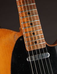 Close-up of a guitar's neck against a dark background