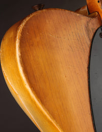 Close up of a Telecaster guitar with a blonde finish on a dark background