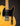 Close-up of a guitar with a black pickguard and blonde wood finish on a dark background