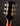 Close-up of a guitar headstock with tuning pegs on a dark background