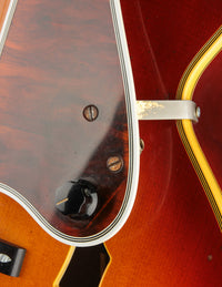 Close up of volume knob and pickguard on a vintage Johnny Smith archtop guitar with a sunburst finish 
