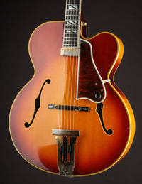 Vintage Johnny Smith archtop guitar with a sunburst finish on a dark background