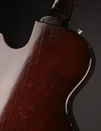 Close-up of a guitar's wooden body with a dark background