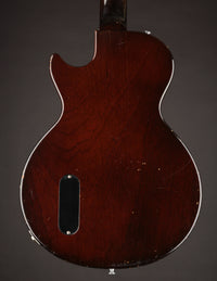 Back view of a wooden electric guitar on a dark background