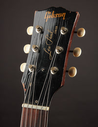 Gibson Les Paul guitar headstock with brand name on a dark background