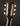 Close-up of a guitar headstock with tuning pegs on a dark background