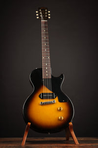 Electric guitar on a stand against a dark background