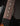 Close-up of a guitar's fretboard with dark wood and white inlays on a black background.