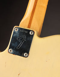 Fender guitar neck plate with serial number on a dark background