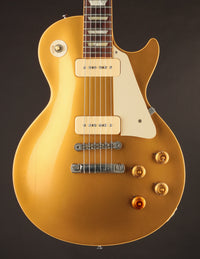 Gold electric guitar on a dark background