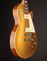 Gold electric guitar on a dark background