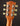 Close-up of a guitar headstock with tuning pegs on a dark background