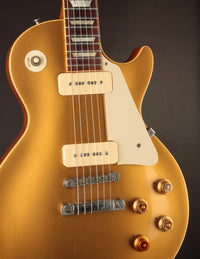 Gold electric guitar with a dark background