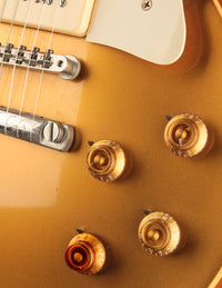 Close-up of a guitar with gold knobs 