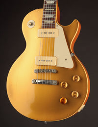 Gold electric guitar on a black background