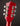Close-up of a red guitar headstock with tuning pegs on a dark background