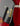 Close-up of a Guild logo on a guitar's pickguard with a red guitar body in the background.