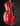 Red electric guitar with a black pickguard on a dark background, from the side