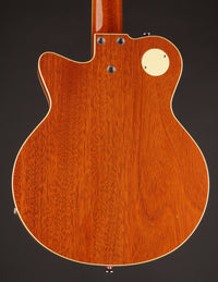 Back view of a wooden guitar with a dark background
