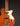 Close-up of a brown electric guitar with a dark background