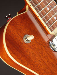 Close-up of a wooden electric guitar with a focus on the neck and body.