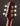 Close-up of a guitar headstock with tuning pegs on a dark background