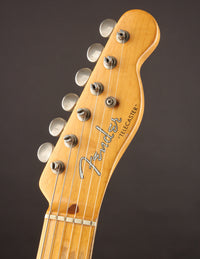 Close-up of a vintage Fender Telecaster guitar headstock on a dark background