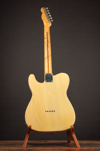 1953 Fender Telecaster guitar on a stand against a dark background, back view