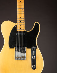 Blonde 1953 Fender Telecaster body, close up on a dark background