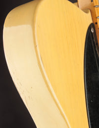 Close-up of a guitar's body with a focus on the wood grain and finish.